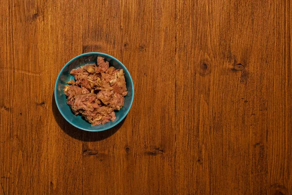 Top view of bowl full of tuna on wooden background — Stock Photo, Image