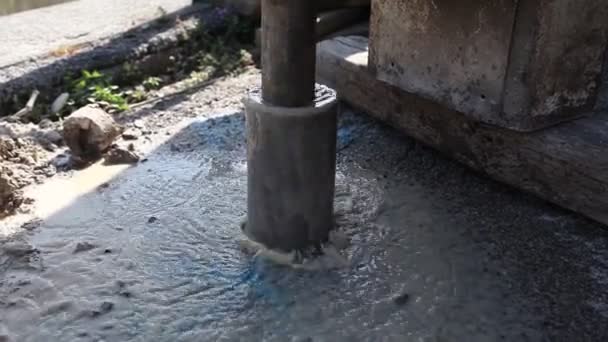 Detail of rotary drilling machinery in action with water coming out of subsoil — Stock Video