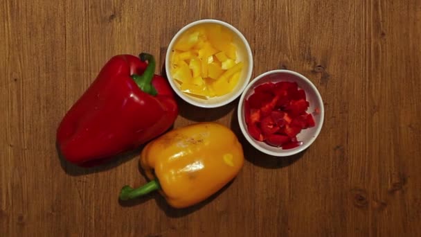 Zoom op hele en gehakte rode en gele paprika 's — Stockvideo