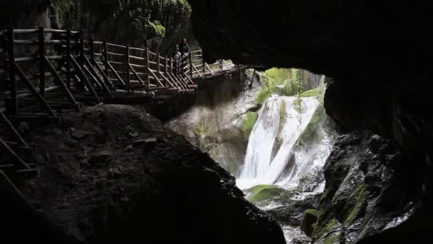 Cinemagraph efeito de cachoeiras em uma caverna com pessoas irreconhecíveis — Vídeo de Stock