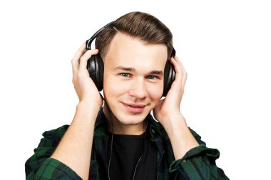 Beyaz, beyaz, genç bir adam portresi kulak telefonları müzik dinle. Siyah T-shirt ve beyaz izole zemin üzerine yeşil ekose gömlek giymiş yakışıklı adam