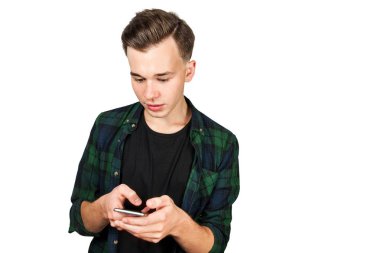 Beyaz genç adam üstünde belgili tanımlık hareket eden telefon ve gülümser bir ileti yazar. Beyaz bir arka plan üzerinde izole