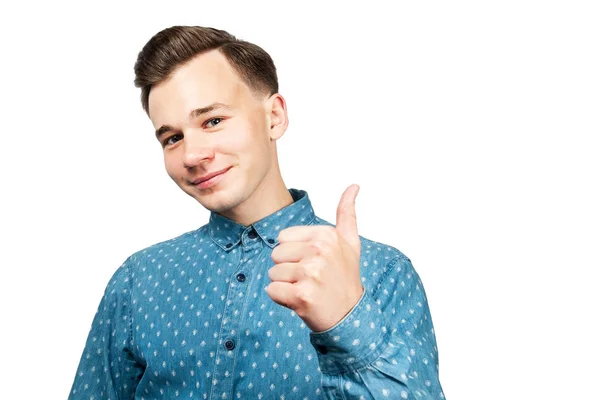 Öltözve kék ing, fehér fiatal srác azt mutatja, hogy remek, mosolyog, és keres elszigetelt fehér alapon — Stock Fotó