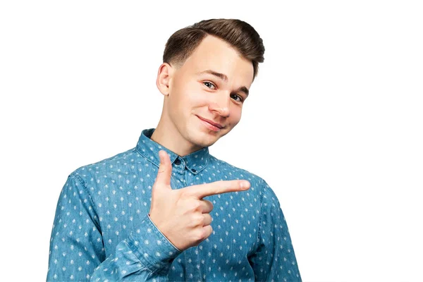 Blanc jeune homme habillé en chemise bleue pointe index de côté et sourit sur fond blanc isolé — Photo