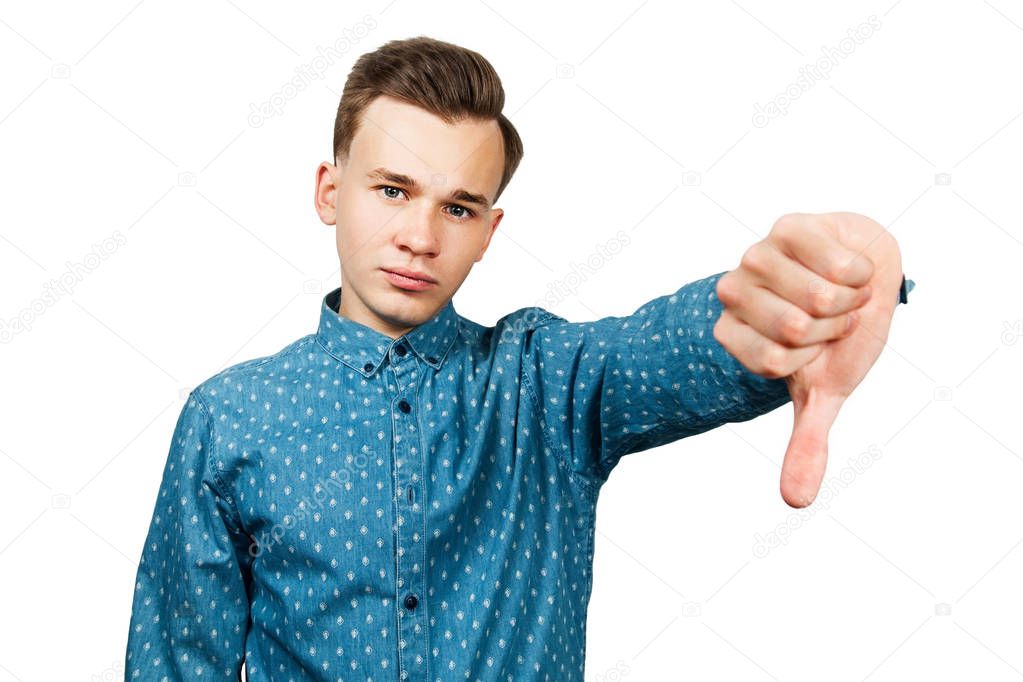 White young man dressed in blue shirt showing thumbs down. Isolated on a white background