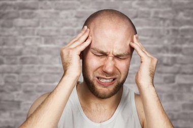 adam antibiyotik alarak, antidepresan, hap ilaç evde ağrı rahatlatmak için. Genç adam hasta, kötü baş ağrısı, stres veya grip, tuğla duvar arka planda acil tedavi kavramı muzdarip