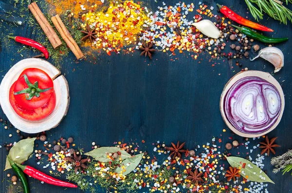 Набор приправ и специй на деревянном голубом фоне с помидорами, луком. чеснок, перец — стоковое фото