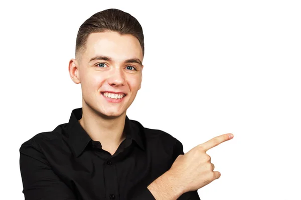 Blanke jongeman gekleed in een zwart shirt geïsoleerd op witte achtergrond punten opzij index vinger en glimlacht — Stockfoto