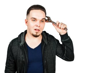 Ayarlanabilir İngiliz anahtarı tutan sakallı genç adamın portresi. beyaz arka plan üzerinde izole