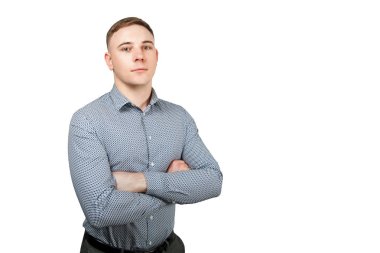 Mavi gömlek giymiş ve kolları çapraz olan yakışıklı genç adamın portresi. Beyaz arka planda yalıtılmış