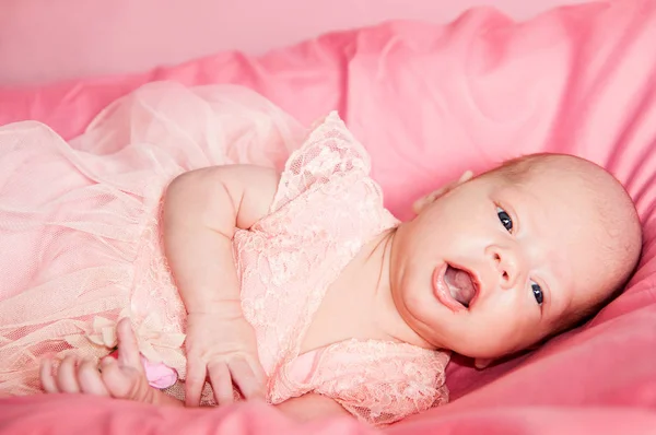 Close up retrato de bebê recém-nascido menina vestida com um vestido rosa, com uma coroa e uma flor na cabeça — Fotografia de Stock