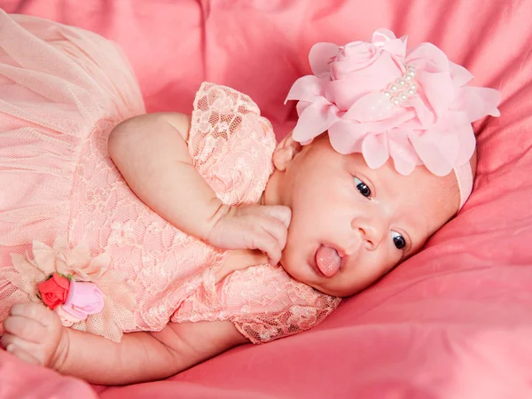 Bebé recién nacido niña en vestido rosa y corona de ganchillo, se encuentra en la cama rosa . — Foto de Stock