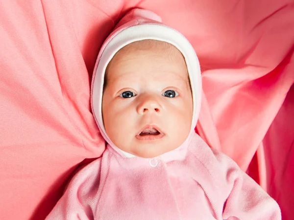 Bebé recién nacido niña en vestido rosa y corona de ganchillo, se encuentra en la cama rosa . — Foto de Stock