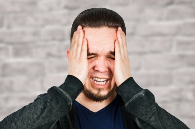 adam antibiyotik alarak, antidepresan, hap ilaç evde ağrı rahatlatmak için. Genç adam hasta, kötü baş ağrısı, stres veya grip, tuğla duvar arka planda acil tedavi kavramı muzdarip