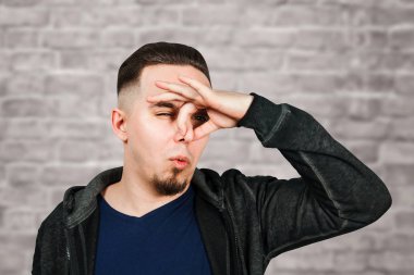 Kafkas adam portresi, yakın burun, kokuyor. Tuğla duvar arka plan üzerinde Adam