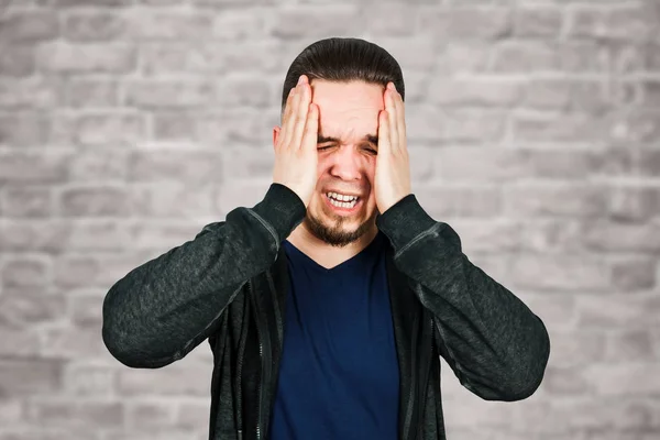 Hombre tomando antibiótico, antidepresivo, medicación de la píldora para aliviar dolor en el hogar. Joven enfermo, enfermo que sufre de dolor de cabeza, estrés o gripe, concepto de tratamiento de emergencia en el fondo de la pared de ladrillo — Foto de Stock