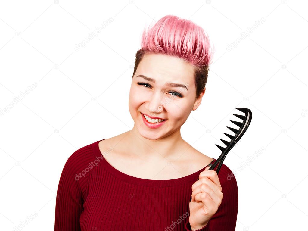 Portrait of beautiful girl with short hairstyle holding comb and smiles. Isolated on white background