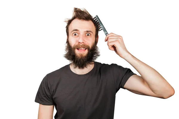 Joven barbudo sobrecrecido hombre sosteniendo peine y peinándose el pelo. Aislado sobre fondo blanco —  Fotos de Stock