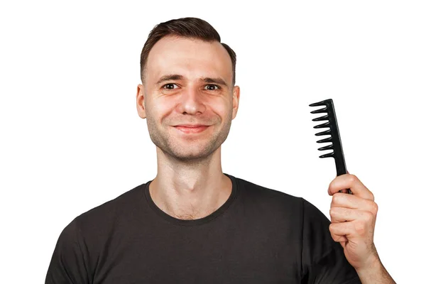 Молодий чоловік з посмішкою тримає волосся гребінцем. Ізольовані на білому тлі — стокове фото