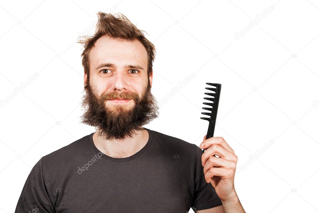 Young bearded overgrown man holding comb. Isolated on white background