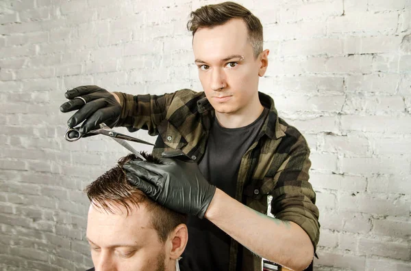 Barber couper les cheveux et peigne homme adulte sur un fond de mur de briques. Gros plan portrait d'un gars — Photo