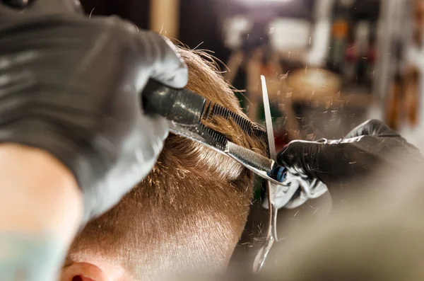 Friseurhände schneiden Haare und kämmen erwachsenen Mann auf einer Ziegelwand Hintergrund. Nahaufnahme Porträt eines Mannes — Stockfoto