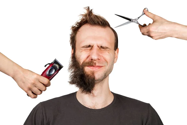 Hand with clipper and hand with scissors cut overgrown unshaven guy with a beard on a white isolated background — Stock Photo, Image