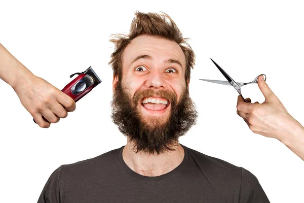 Hand with clipper and hand with scissors cut overgrown unshaven guy with a beard on a white isolated background — Stock Photo, Image