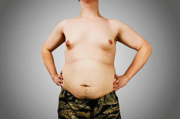 초과 중량을 가진 젊은 남자의 몸, 회색 배경에 배꼽 지방을 유지. — 스톡 사진