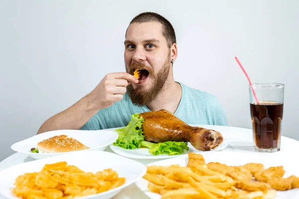 一个带着胡子的家伙在家里吃些没用的快餐 — 图库照片