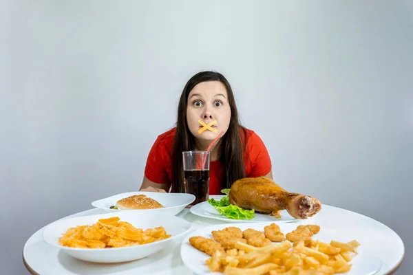 Gruba Kobieta Zaklejonymi Ustami Siedzi Przy Stole Fast Foodem — Zdjęcie stockowe