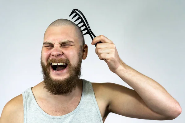 一个留着胡子的秃头男人手里拿着一把刷子的画像 脱发和头发移植的概念 — 图库照片