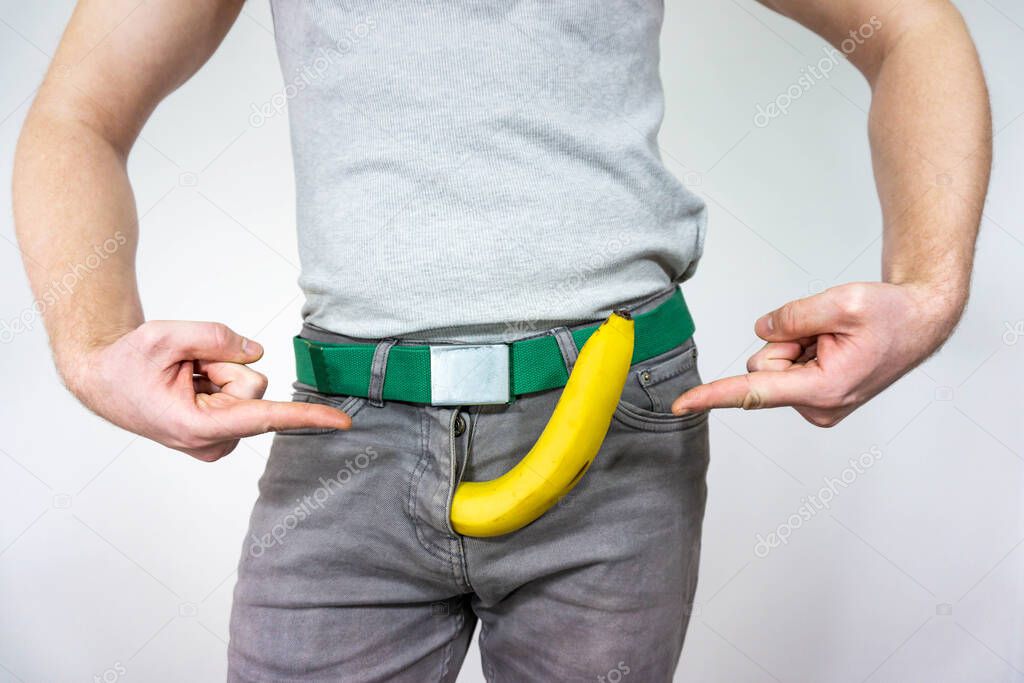 A man imitates a penis with a banana. concept of men's health, potency and large size