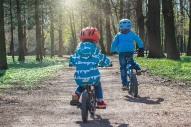 Parkta bisiklete binen iki çocuk. Çocuklarla spor yaşam tarzı.
