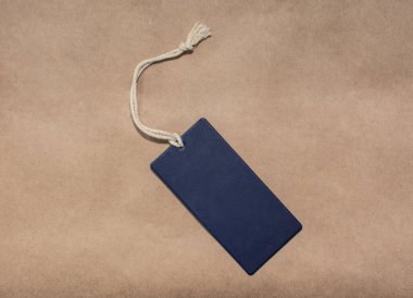 Kağıt arkaplanda tek bir mavi giysi etiketinin kopyası.