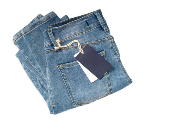 Blauwe vrouw gevouwen jeans met een blauw label tag geïsoleerd op witte achtergrond. — Stockfoto