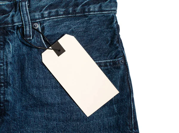 Bolsillo de jeans azules con etiqueta blanca. Bolsillo con una etiqueta de primer plano aislada en blanco . — Foto de Stock