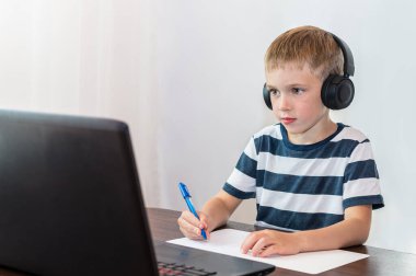 Kulaklıklı küçük çocuk çevrimiçi ders veriyor. Çevrimiçi eğitim.