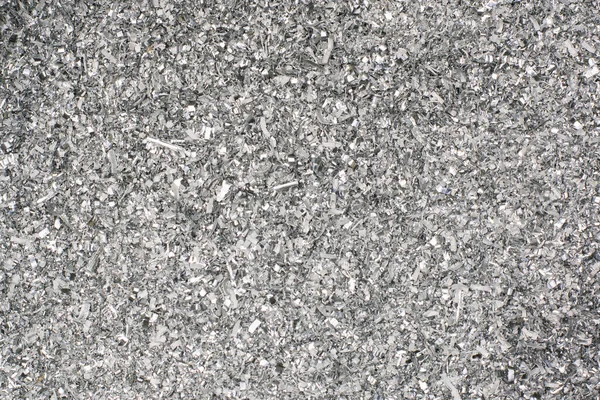 Abstract background and texture of metal shavings. Aluminum chip waste after machining metal parts on a cnc lathe. Silver texture pattern. Pile of metal shavings. — Stock Photo, Image