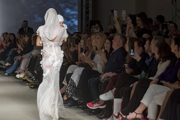 Atina, Yunanistan, 03/29/2018, sarışın model podyum defile sırasında bir bebek tutan