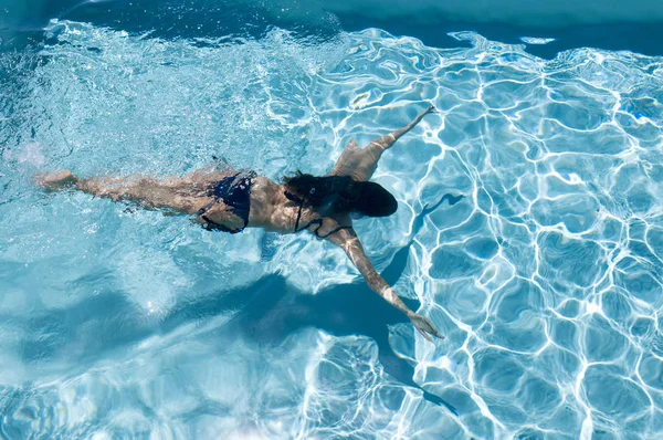 女性は水のプールで彼女の休日を楽しんでいます — ストック写真