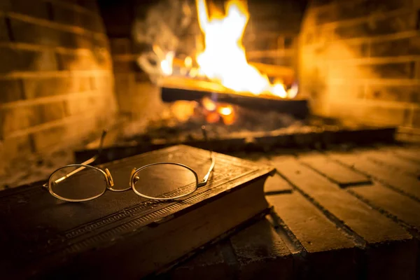 Şöminenin Yanında Üzerine Gözlük Ile Eski Kitap — Stok fotoğraf