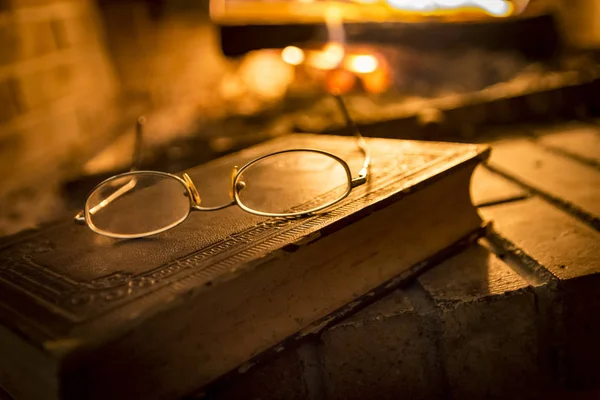 Şöminenin Yanında Üzerine Gözlük Ile Eski Kitap — Stok fotoğraf