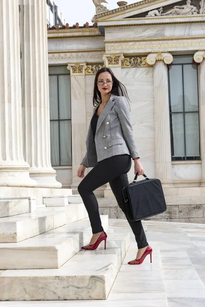 Business woman climbs marble stairs