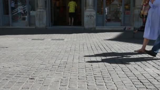 スローモーションで通り過ぎる背景に電動スクーターで歩くカップルの足 — ストック動画