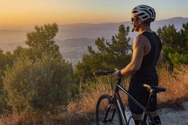 Erkek motorcu gün batımını izliyor
