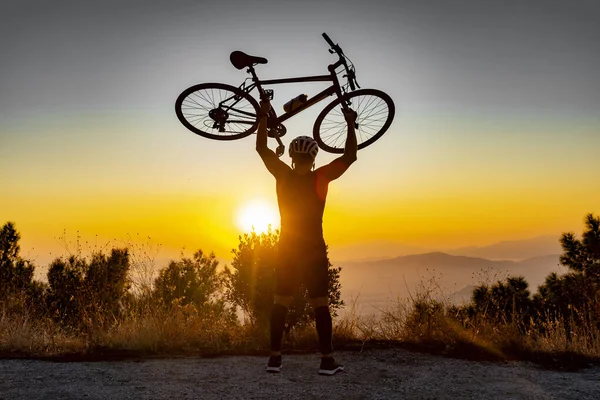 Male biker holds bike above head — Stock Photo, Image