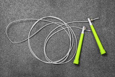 Fitness salonunda gri bir arka plan üzerinde yeşil ip