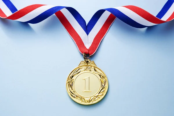 Χρυσό Μετάλλιο Μέρος Κορδέλα Ανοιχτό Μπλε Φόντο Έννοια Της Νίκης — Φωτογραφία Αρχείου