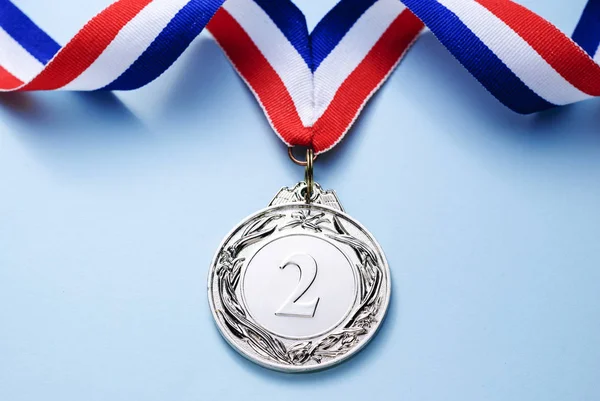 明るい青の背景 勝利や成功のコンセプトのリボンと銀メダル — ストック写真